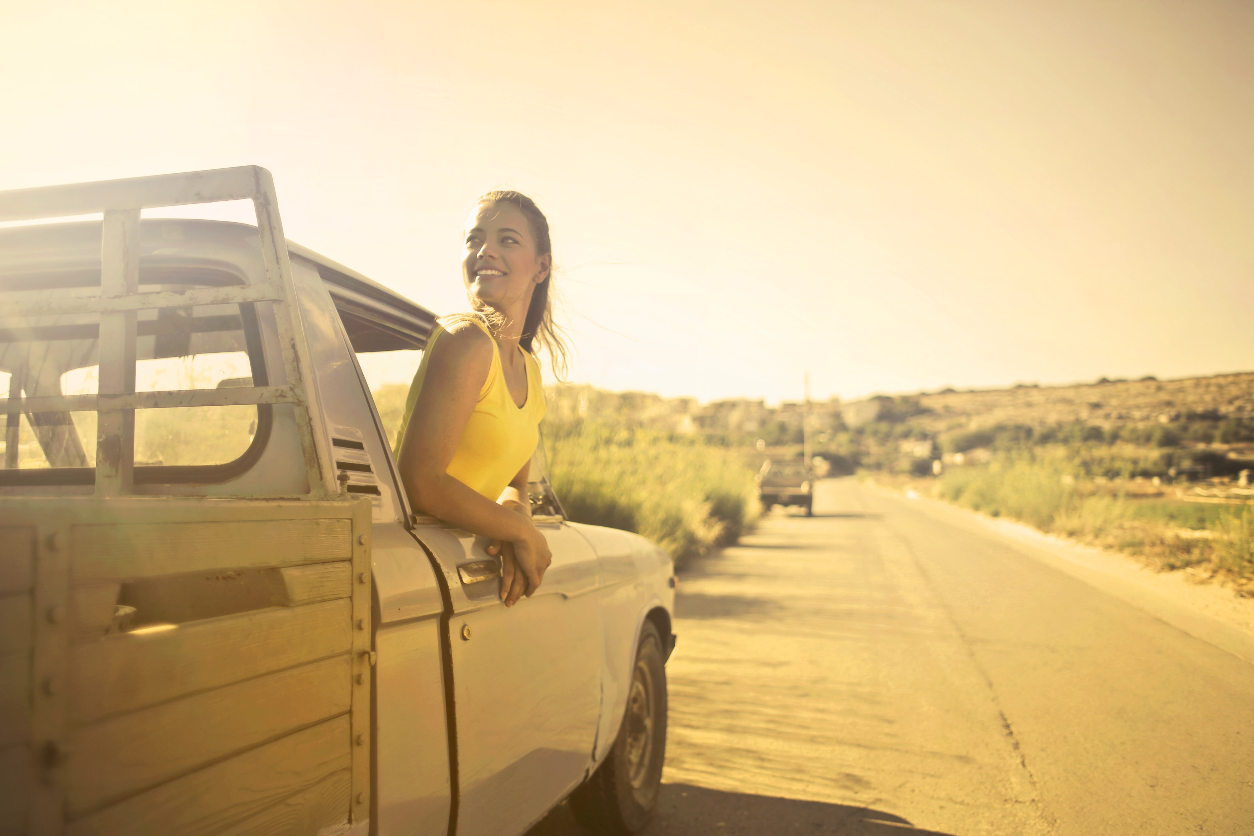 Photo d'une fille en voiture, sortant la tête par la fenêtre pour admirer la route !